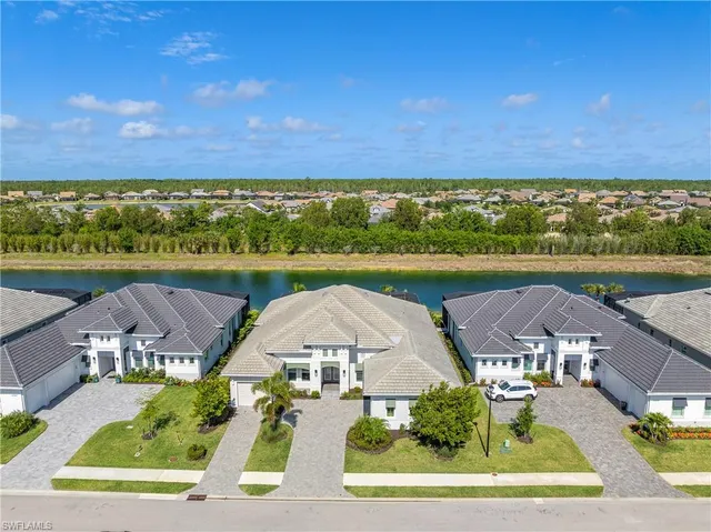 an aerial view of residential houses with outdoor space and ocean view