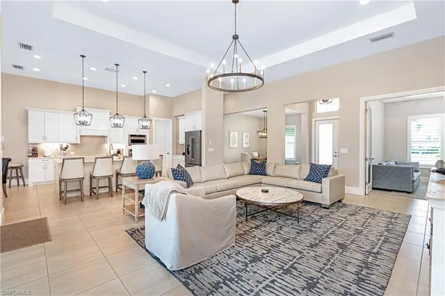 a large room with lots of white furniture and chandelier