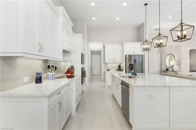 a large kitchen with stainless steel appliances lots of counter space and a sink
