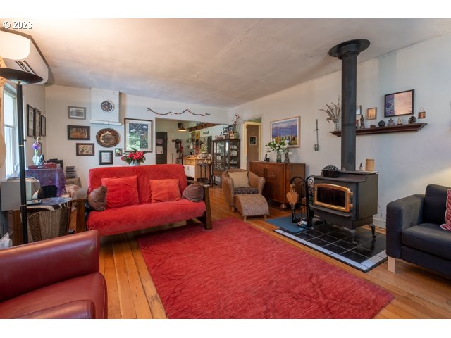 32175 Upper Nestucca River Road Beaver, OR 97108 - Photo 12 of 21 a living room with furniture a fireplace and a flat screen tv