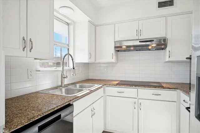 a kitchen with stainless steel appliances granite countertop a sink a stove and cabinets