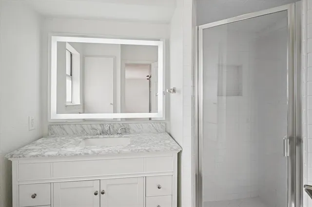 a bathroom with a granite countertop sink and mirror
