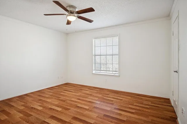 a view of a big room with wooden floor and windows