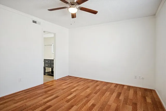 an empty room with a window and ceiling fan