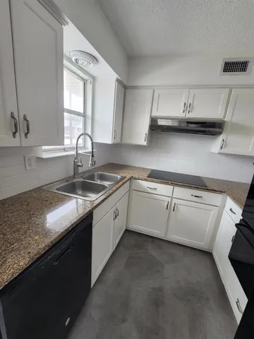 a kitchen with a sink cabinets and window
