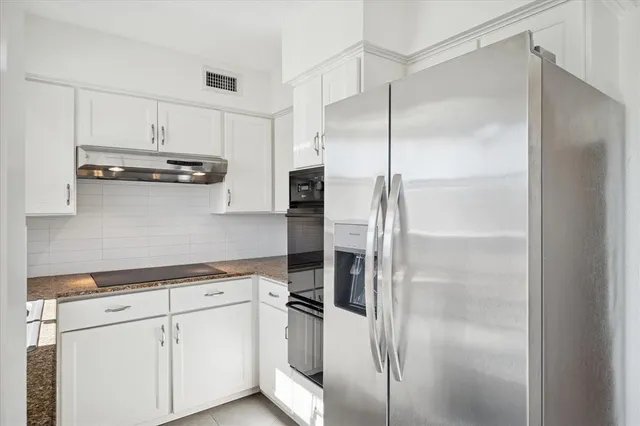 a kitchen with cabinets and stainless steel appliances