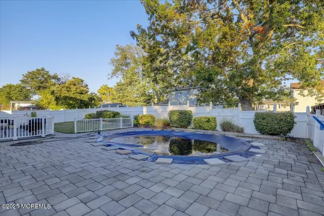 a view of backyard with swimming pool and seating