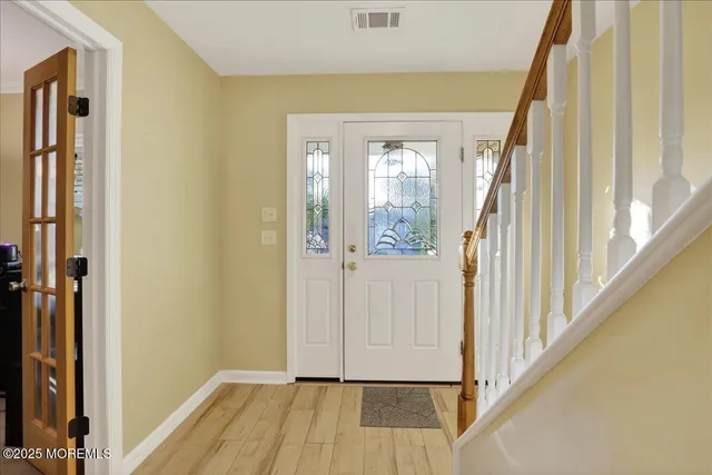 a view of a hallway with wooden floor and staircase