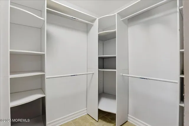 a view of walk in closet with empty racks