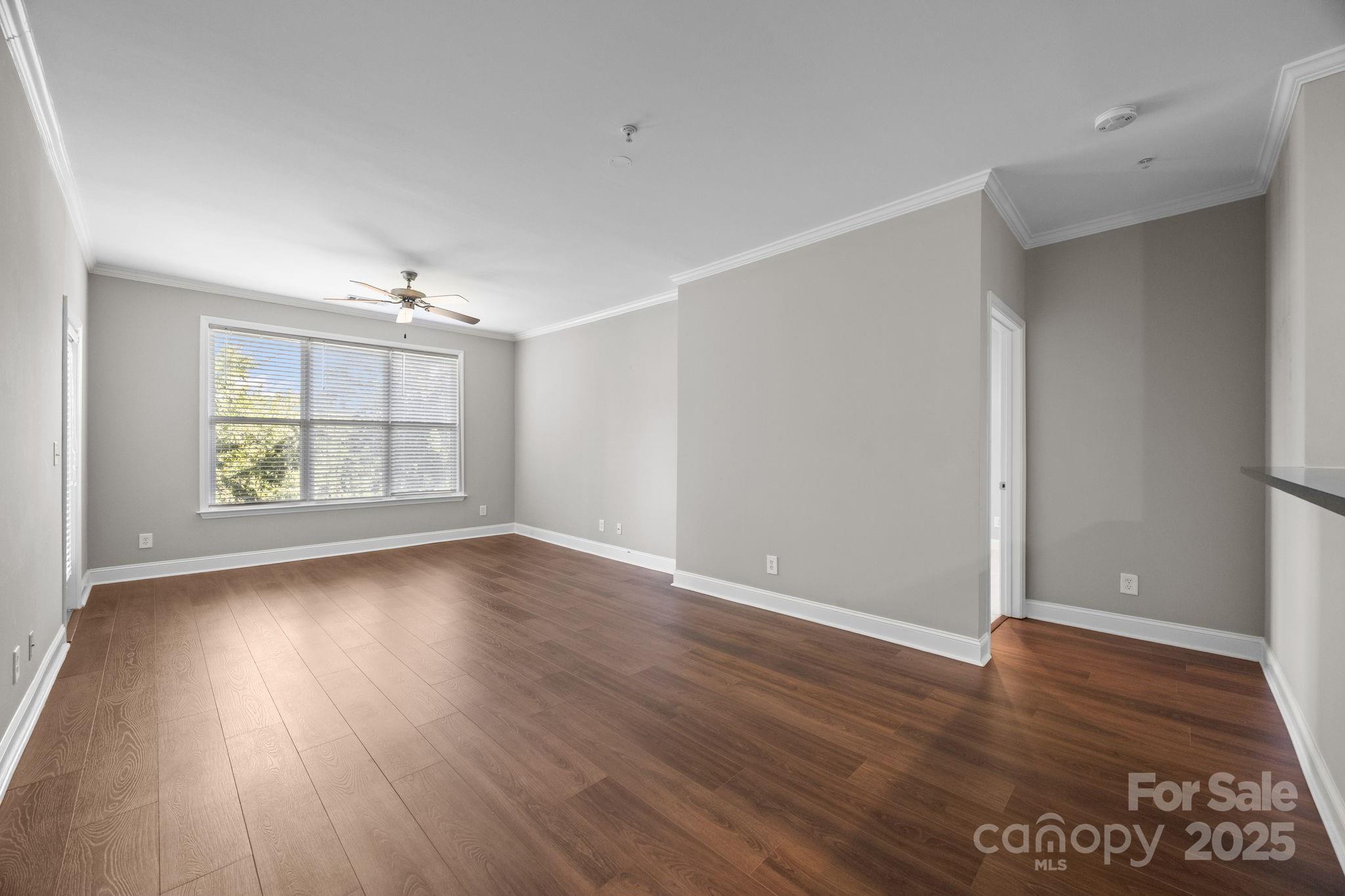 1000 East Woodlawn Road, Unit 413 Charlotte, NC 28209 - Photo 9 of 32 an empty room with wooden floor and windows
