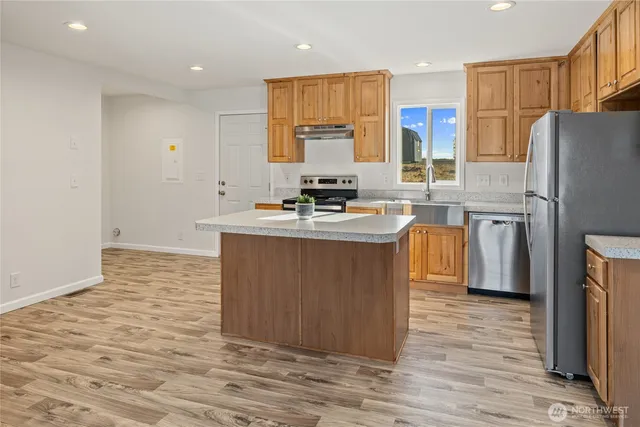 a kitchen with stainless steel appliances granite countertop a sink stove and refrigerator