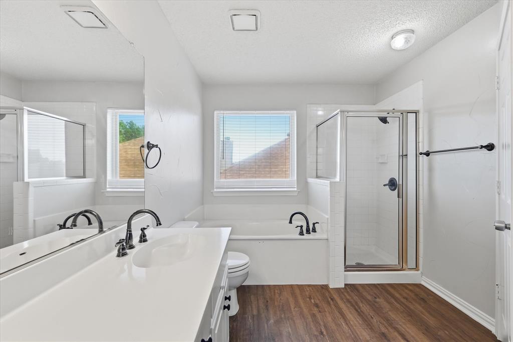 318 Lodge Road Coppell, TX 75019 - Photo 24 of 35 A separate glass-enclosed shower and relaxing soaking tub create a comfortable, functional primary bath layout.