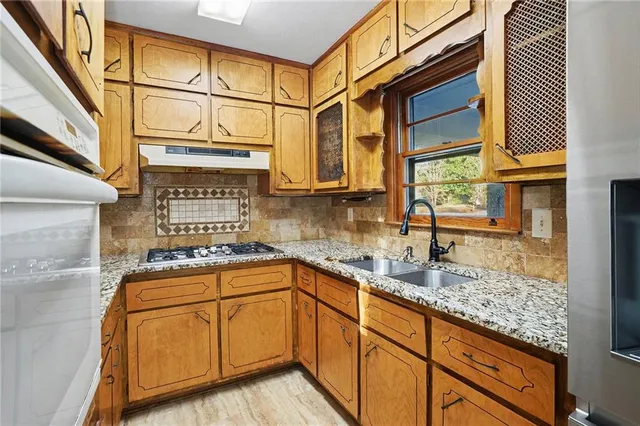 a kitchen with stainless steel appliances granite countertop a sink and cabinets