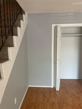 a view of an empty room with wooden floor and entryway