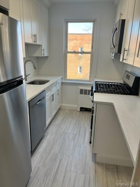 a kitchen with a sink a refrigerator a window and cabinets