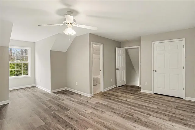 a view of a room with wooden floor and a ceiling fan