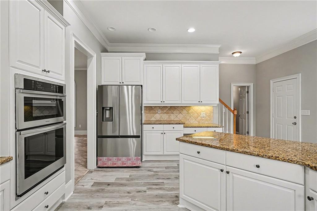 25 Inverleigh Row Covington, GA 30014 - Photo 9 of 28 a kitchen with granite countertop stainless steel appliances a refrigerator cabinets and microwave