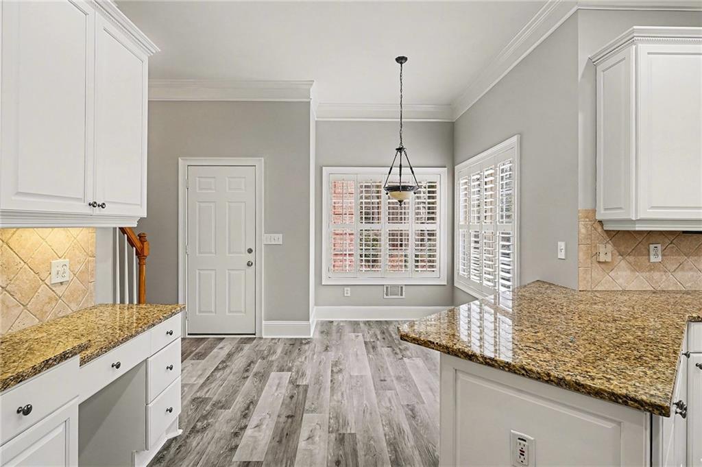 25 Inverleigh Row Covington, GA 30014 - Photo 10 of 28 a view of a kitchen with granite countertop a sink and dishwasher wooden cabinets with a large window