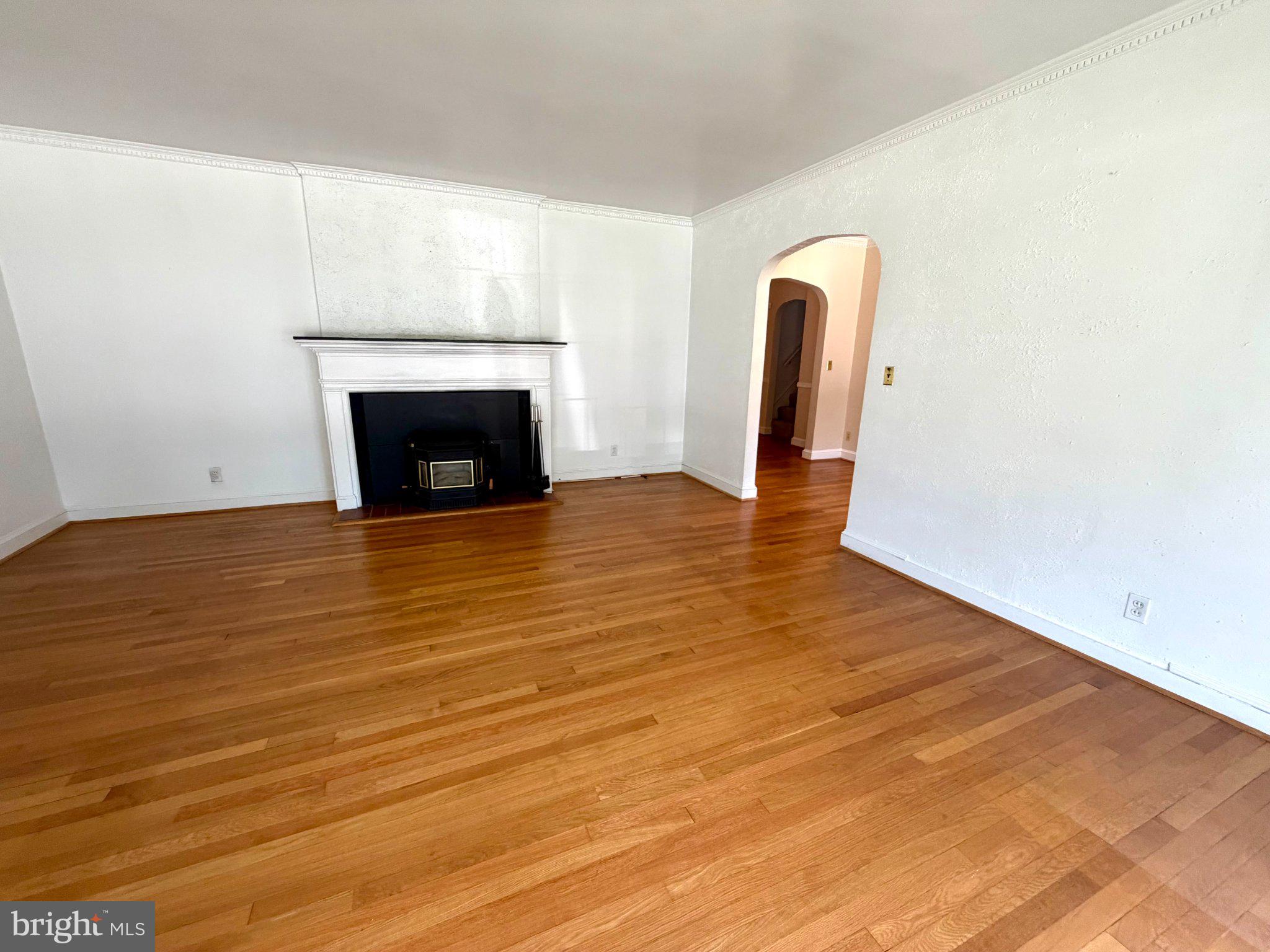 6318 Winner Avenue Baltimore, MD 21215 - Photo 13 of 75 a view of an empty room with wooden floor and a fireplace