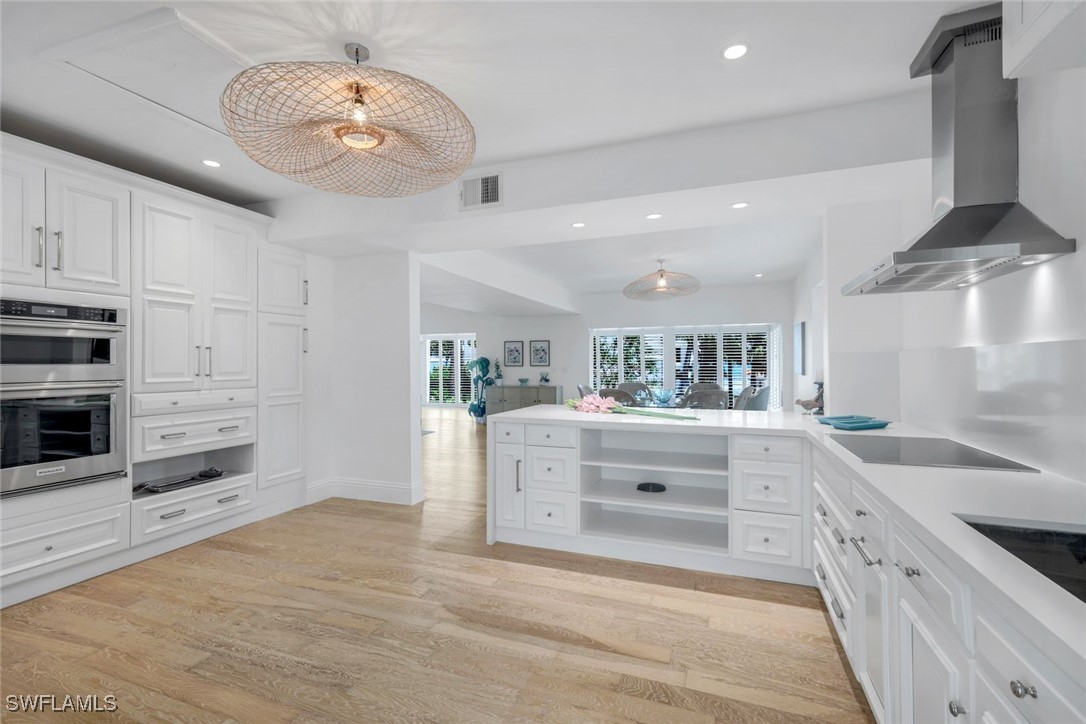 513 Lighthouse Way Sanibel, FL 33957 - Photo 12 of 44 a large white kitchen with kitchen island a stove a sink and dishwasher with white cabinets