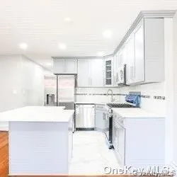 a kitchen with kitchen island stainless steel appliances a sink and refrigerator