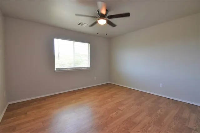 an empty room with a window and a fan