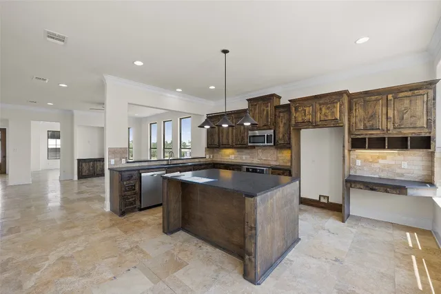 a kitchen with stainless steel appliances granite countertop a sink a stove and a refrigerator