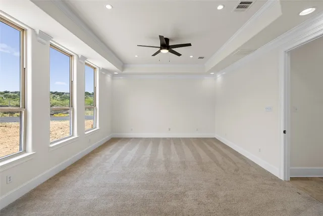 en empty room with windows and ceiling fan