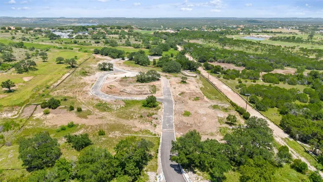 an aerial view of residential houses with outdoor space and trees