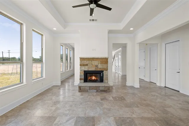 a view of an empty room with a window and fireplace