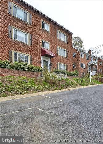 8708 Bradford Road, Unit 301 Silver Spring, MD 20901 - Photo 1 of 13 a view of a brick building next to a yard