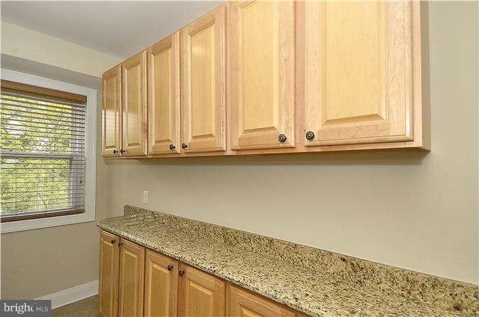 8708 Bradford Road, Unit 301 Silver Spring, MD 20901 - Photo 3 of 13 a view of a kitchen with wooden floor and cabinets