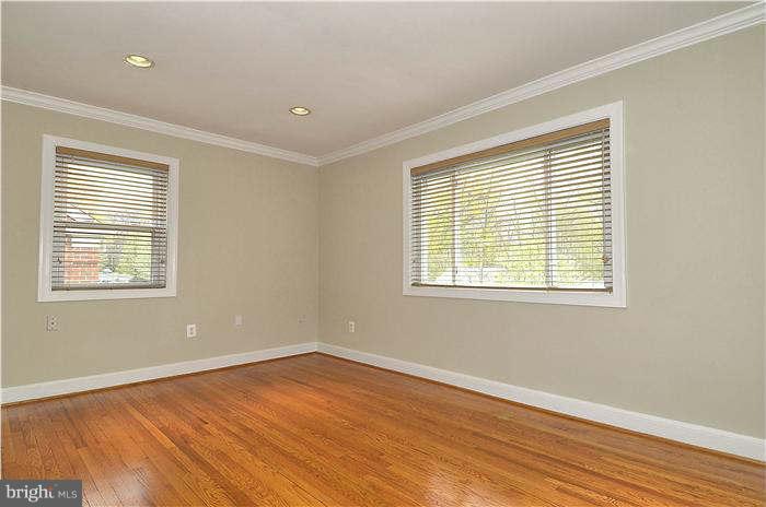 8708 Bradford Road, Unit 301 Silver Spring, MD 20901 - Photo 4 of 13 a view of an empty room with wooden floor and a window