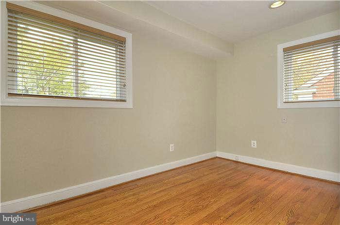 8708 Bradford Road, Unit 301 Silver Spring, MD 20901 - Photo 8 of 13 a view of an empty room with wooden floor and a window