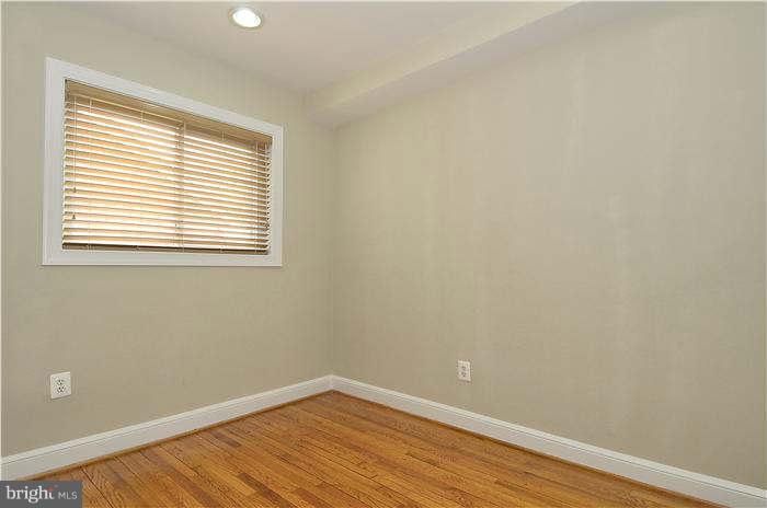 8708 Bradford Road, Unit 301 Silver Spring, MD 20901 - Photo 9 of 13 an empty room with wooden floor and a window