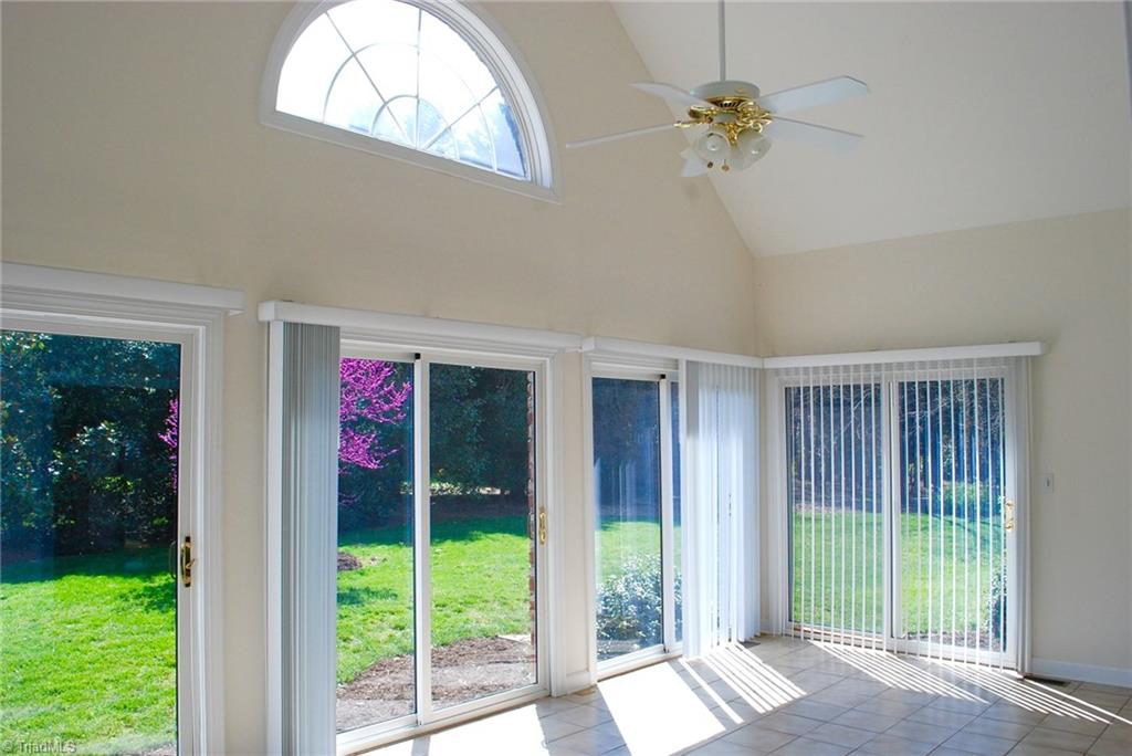 5301 Ridge Trail Road Summerfield, NC 27358 - Photo 12 of 30 Large, sunroom features a cathedral ceiling, tiled flooring & ceiling fan.