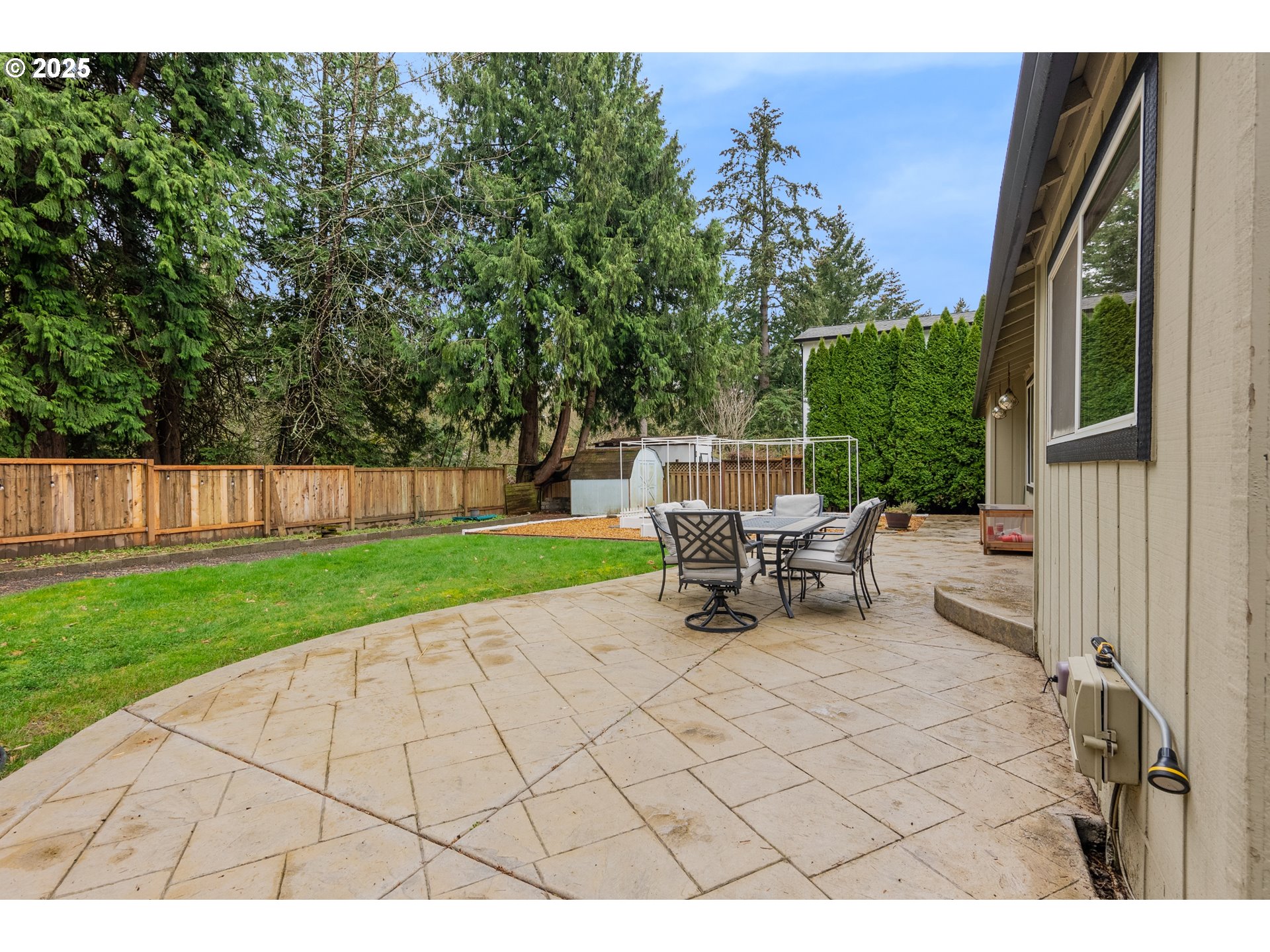 11398 Southwest Ironwood Loop Portland, OR 97223 - Photo 30 of 44 a view of a patio with table and chairs with wooden fence and plants