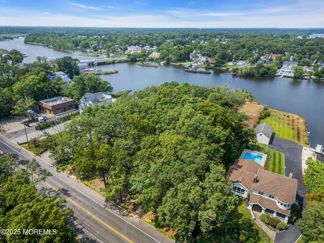 an aerial view of residential houses with outdoor space and lake view