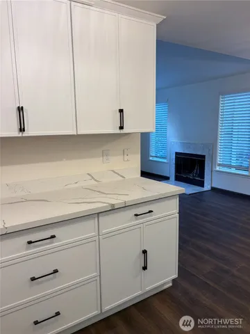 a kitchen with granite countertop white cabinets and white appliances