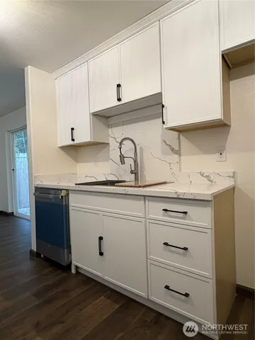 a kitchen with granite countertop white cabinets and white appliances