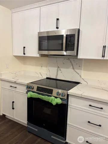 a kitchen with stainless steel appliances a stove microwave and sink