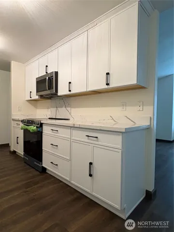 a kitchen with stainless steel appliances granite countertop a stove a sink and a microwave