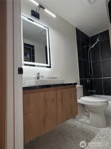 a bathroom with a toilet sink and mirror