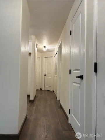 a view of a hallway with wooden floor