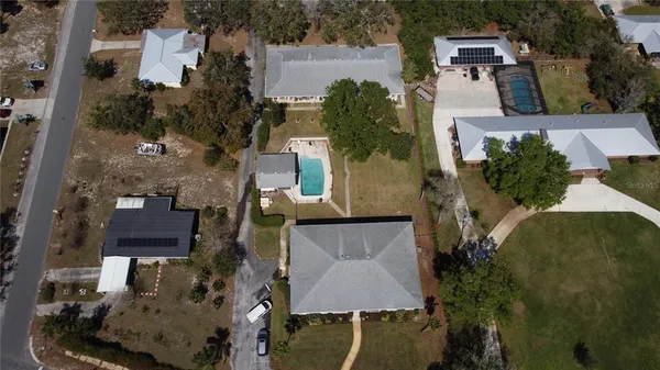 an aerial view of a house with a yard and lake view