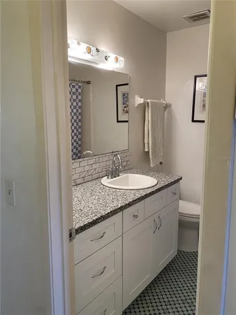 a bathroom with a granite countertop sink and a mirror