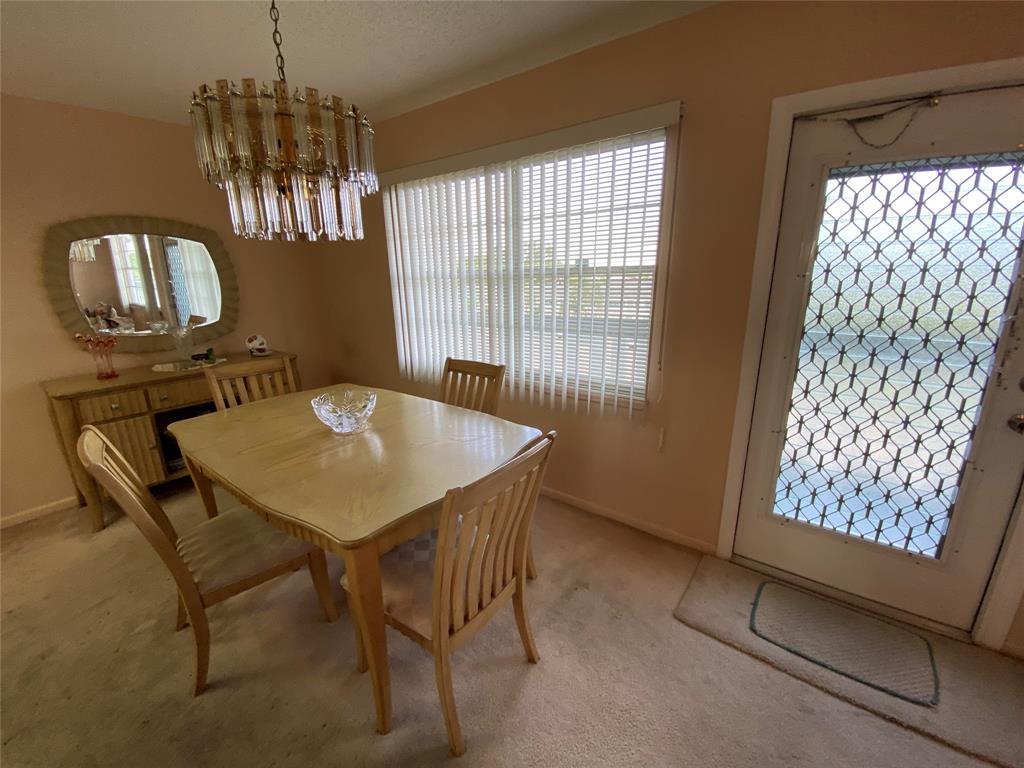 4101 Oakridge V, Unit 4101 Deerfield Beach, FL 33442 - Photo 9 of 42 a view of a dining room with furniture and window