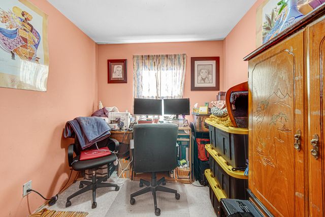 a view of a workspace with furniture and a window