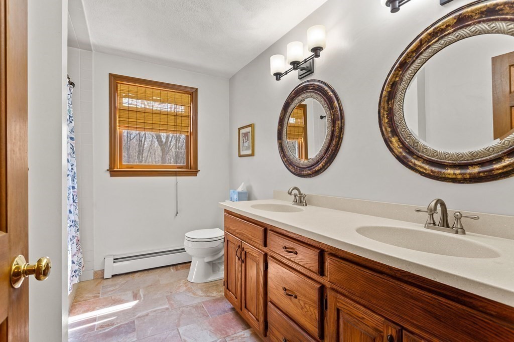 136 Leslie Road Rowley, MA 01969 - Photo 15 of 28 a bathroom with a toilet a sink and a mirror
