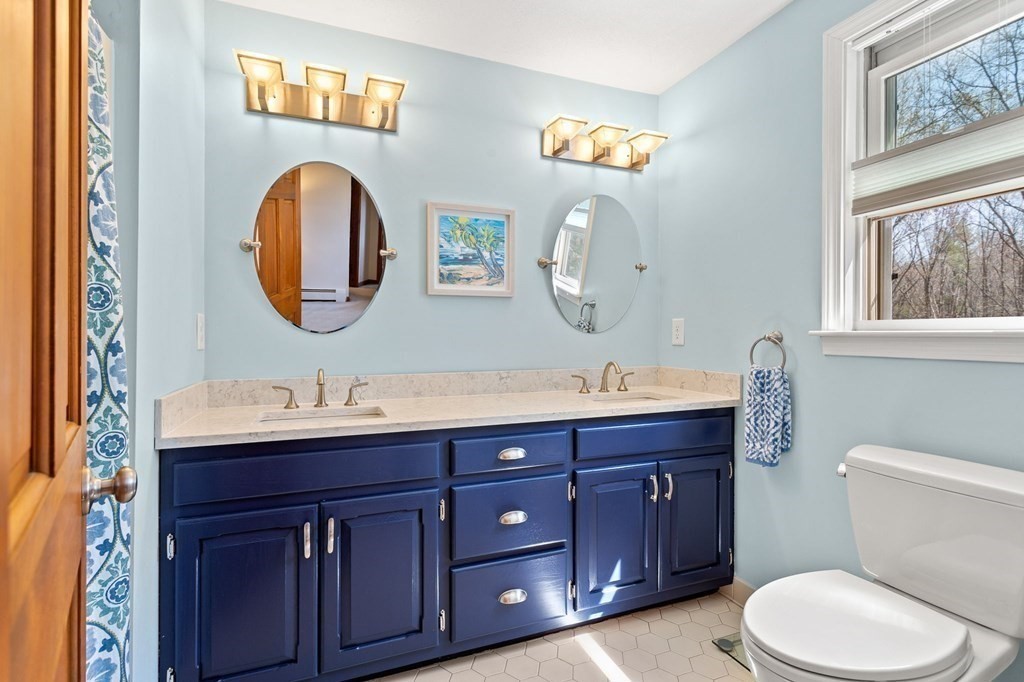 136 Leslie Road Rowley, MA 01969 - Photo 19 of 28 a bathroom with a toilet a sink and a mirror